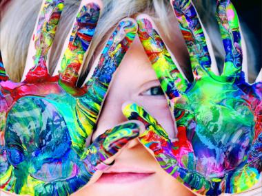 Barn med hænder for ansigtet